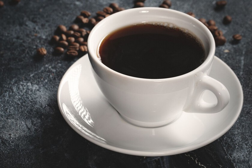 Una taza de café americano con espuma.